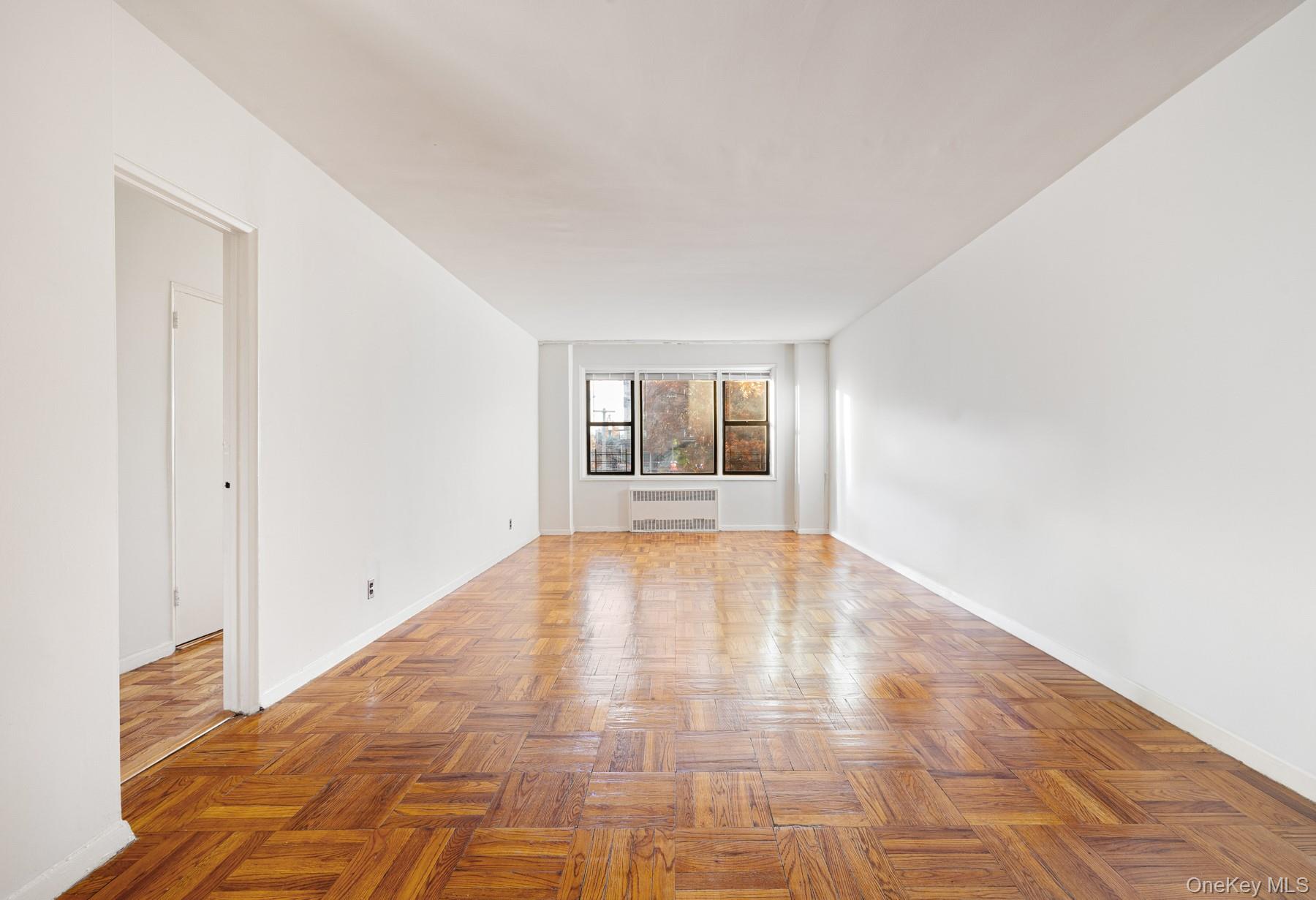 3130 Grand Concourse, Unit 2J Bronx, NY 10458 - Photo 4 of 27 a view of empty room with wooden floor and fireplace
