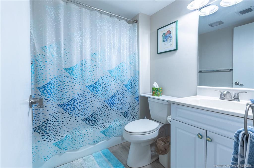 5596 Northeast Gulfstream Way Stuart, FL 34996 - Photo 13 of 21 a bathroom with a sink a toilet and shower