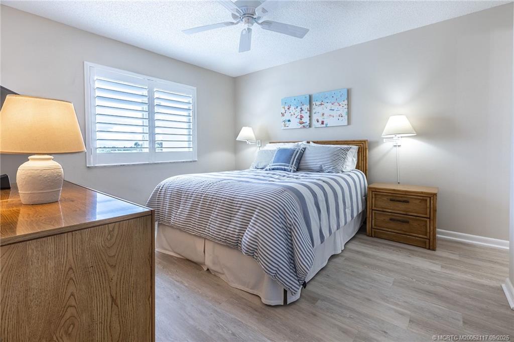 5596 Northeast Gulfstream Way Stuart, FL 34996 - Photo 15 of 21 a bedroom with a bed and a chandelier