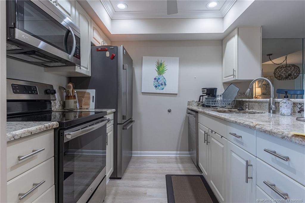 5596 Northeast Gulfstream Way Stuart, FL 34996 - Photo 16 of 21 a kitchen with stainless steel appliances granite countertop a refrigerator and a sink