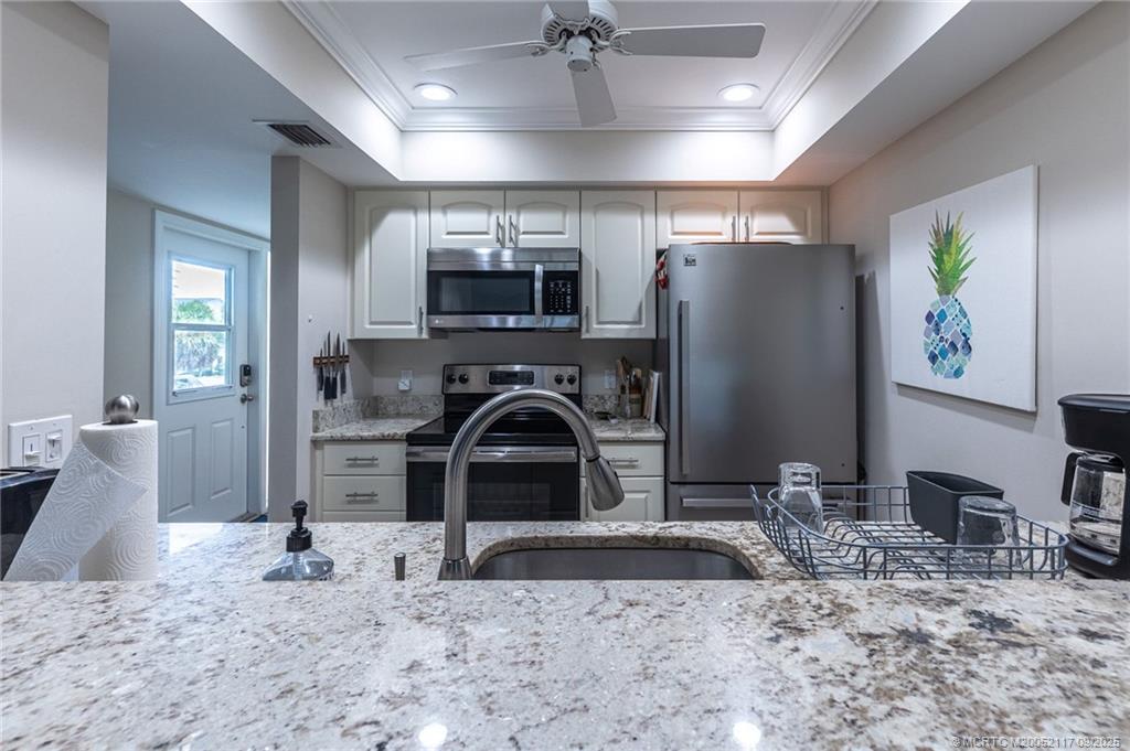5596 Northeast Gulfstream Way Stuart, FL 34996 - Photo 19 of 21 a kitchen with sink refrigerator and microwave