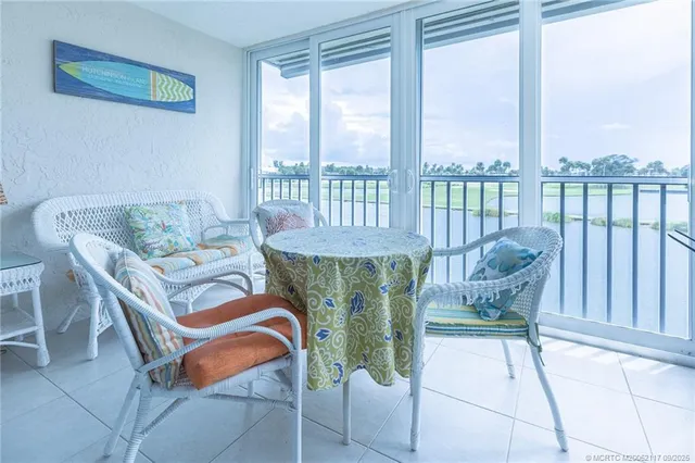 a dining room with furniture and a floor to ceiling window