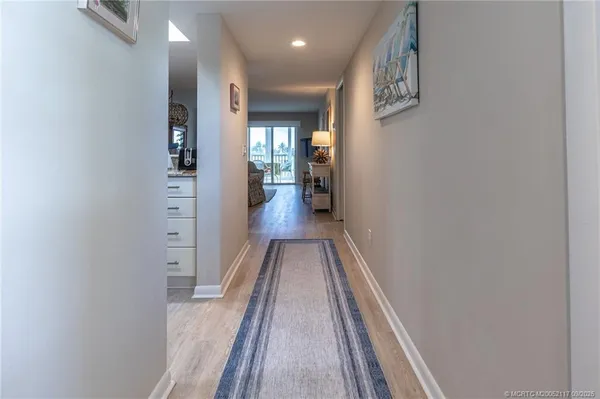 a view of a hallway with wooden floor and staircase