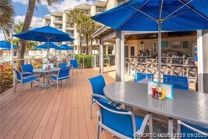 a view of a patio with table and chairs under an umbrella
