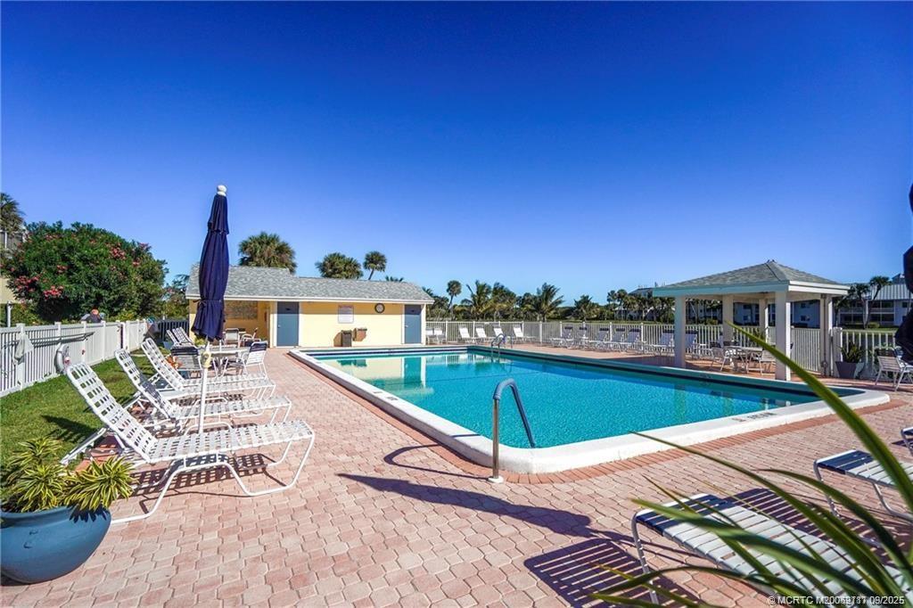 5596 Northeast Gulfstream Way Stuart, FL 34996 - Photo 8 of 21 a view of a swimming pool with lounge chairs