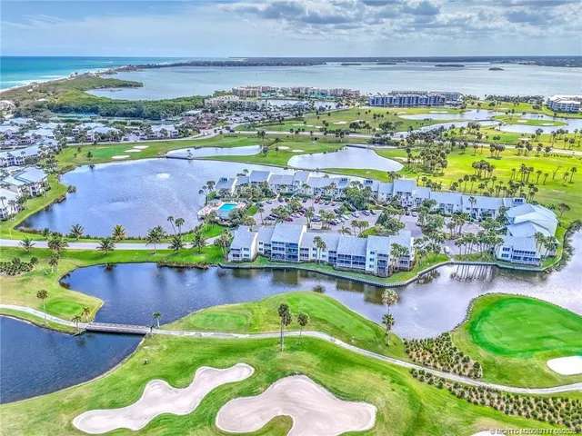 an aerial view of a house with a garden and lake view