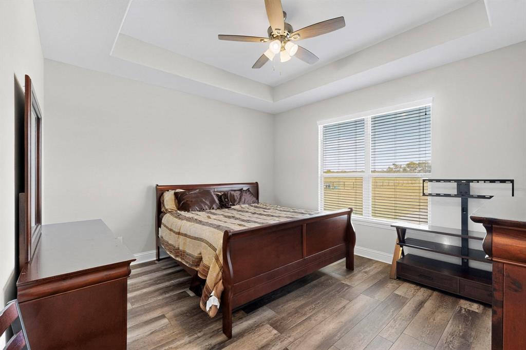 634 Gant Road Sherman, TX 75090 - Photo 24 of 40 Bright interior space featuring wood-finish flooring, a tray ceiling, and a ceiling fan with integrated lighting