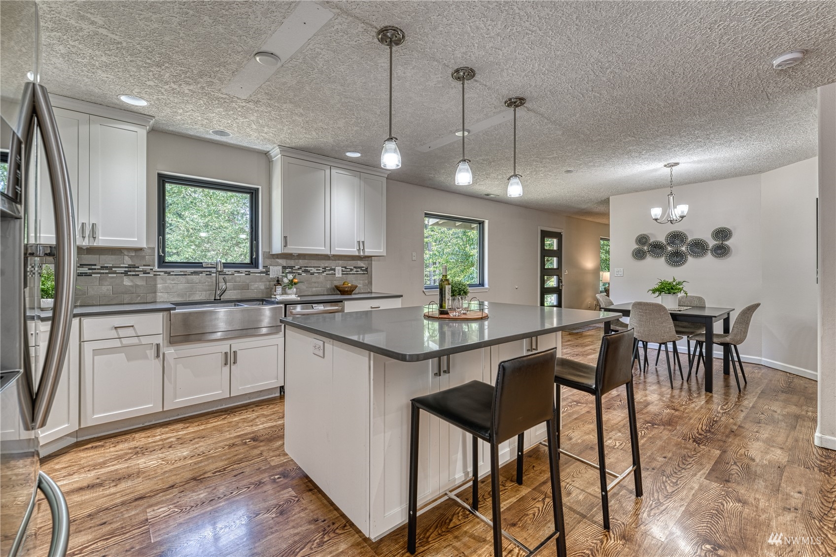 325 Hawkins Road Winlock, WA 98596 - Photo 4 of 40 a kitchen with stainless steel appliances granite countertop wooden floor dining table and chairs
