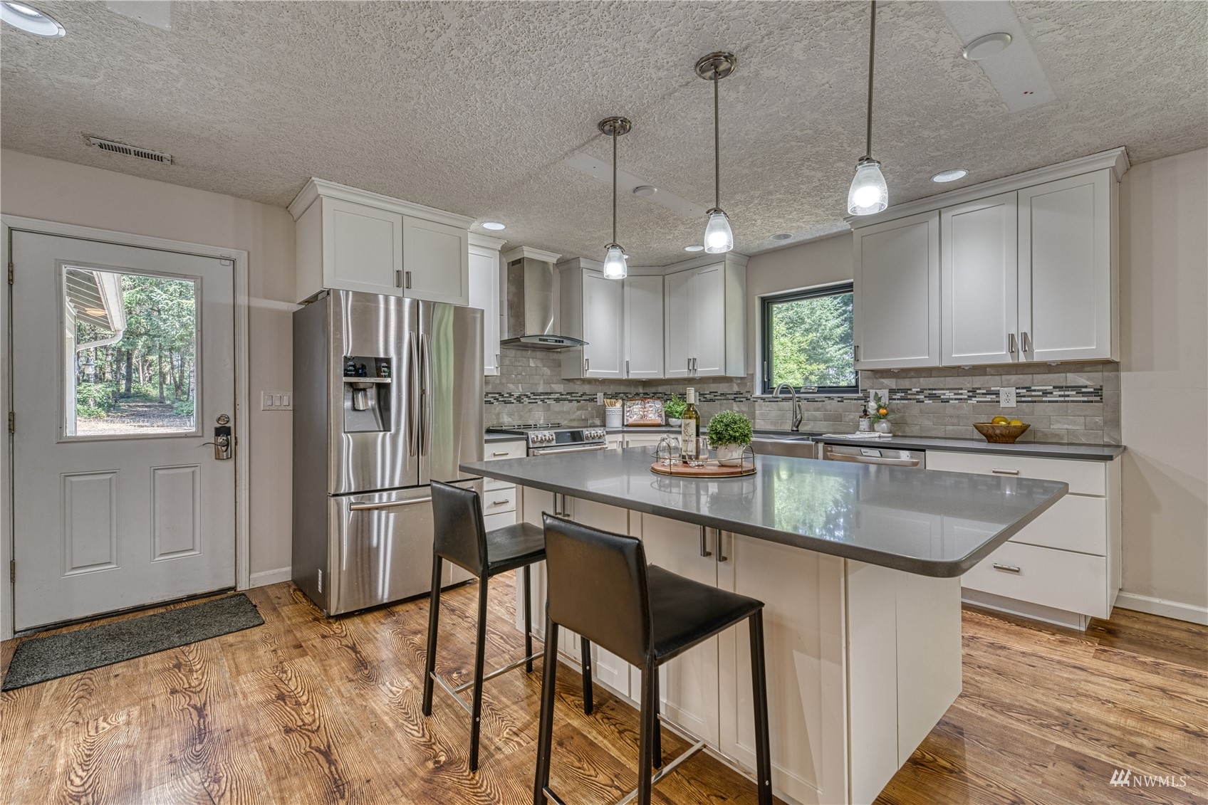 325 Hawkins Road Winlock, WA 98596 - Photo 6 of 40 a kitchen with stainless steel appliances granite countertop a refrigerator a sink dishwasher a stove and white cabinets with wooden floor