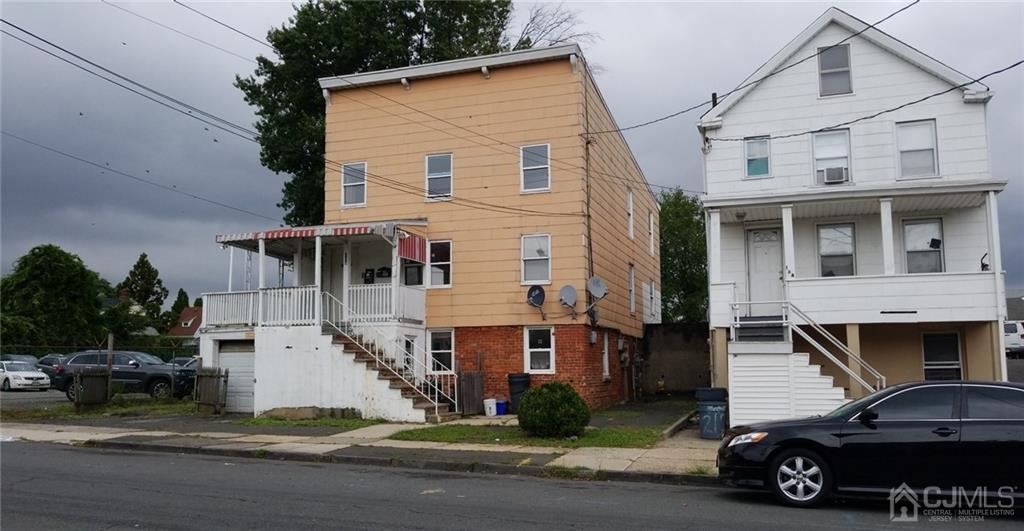 136 Broad Street Perth Amboy, NJ 08861 - Photo 3 of 10 a car parked in front of a white house