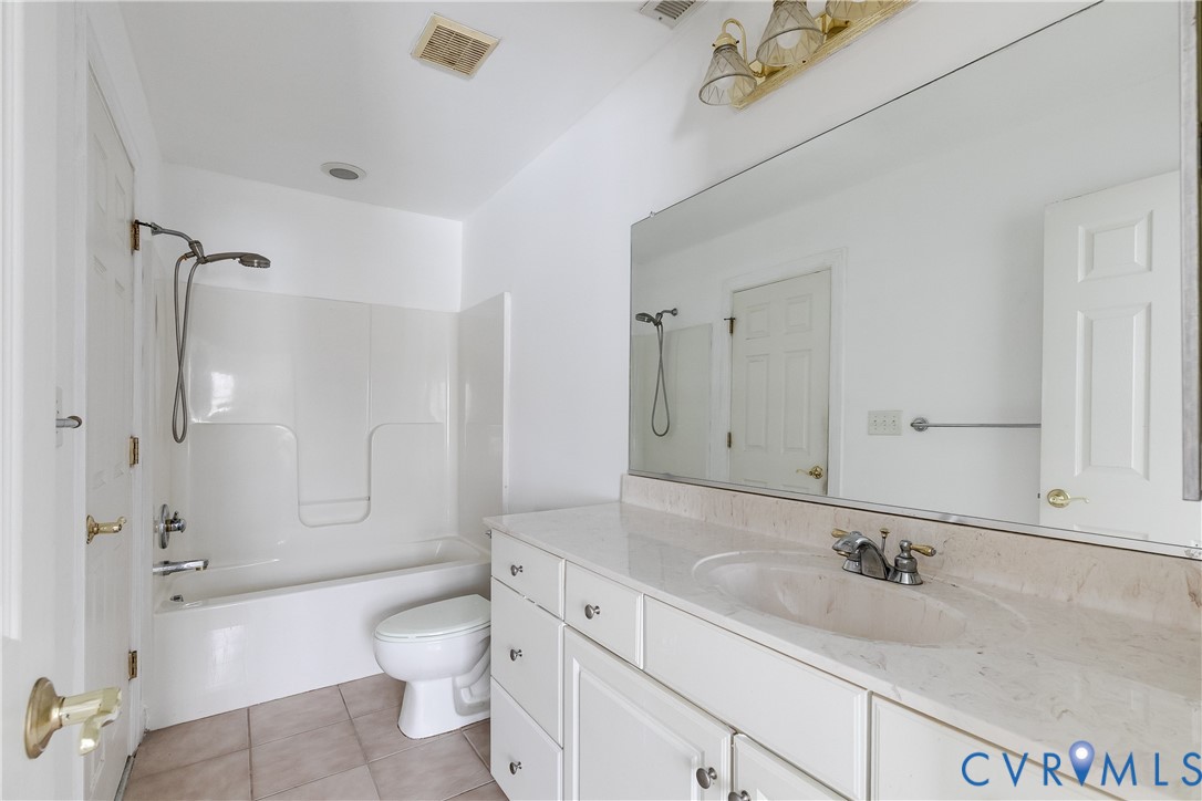 2209 Magnolia Grove Way Midlothian, VA 23113 - Photo 45 of 50 a bathroom with a granite countertop sink toilet mirror and bathtub