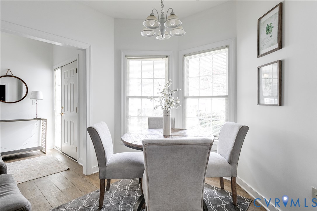2209 Magnolia Grove Way Midlothian, VA 23113 - Photo 9 of 50 a dining room with furniture a chandelier and wooden floor