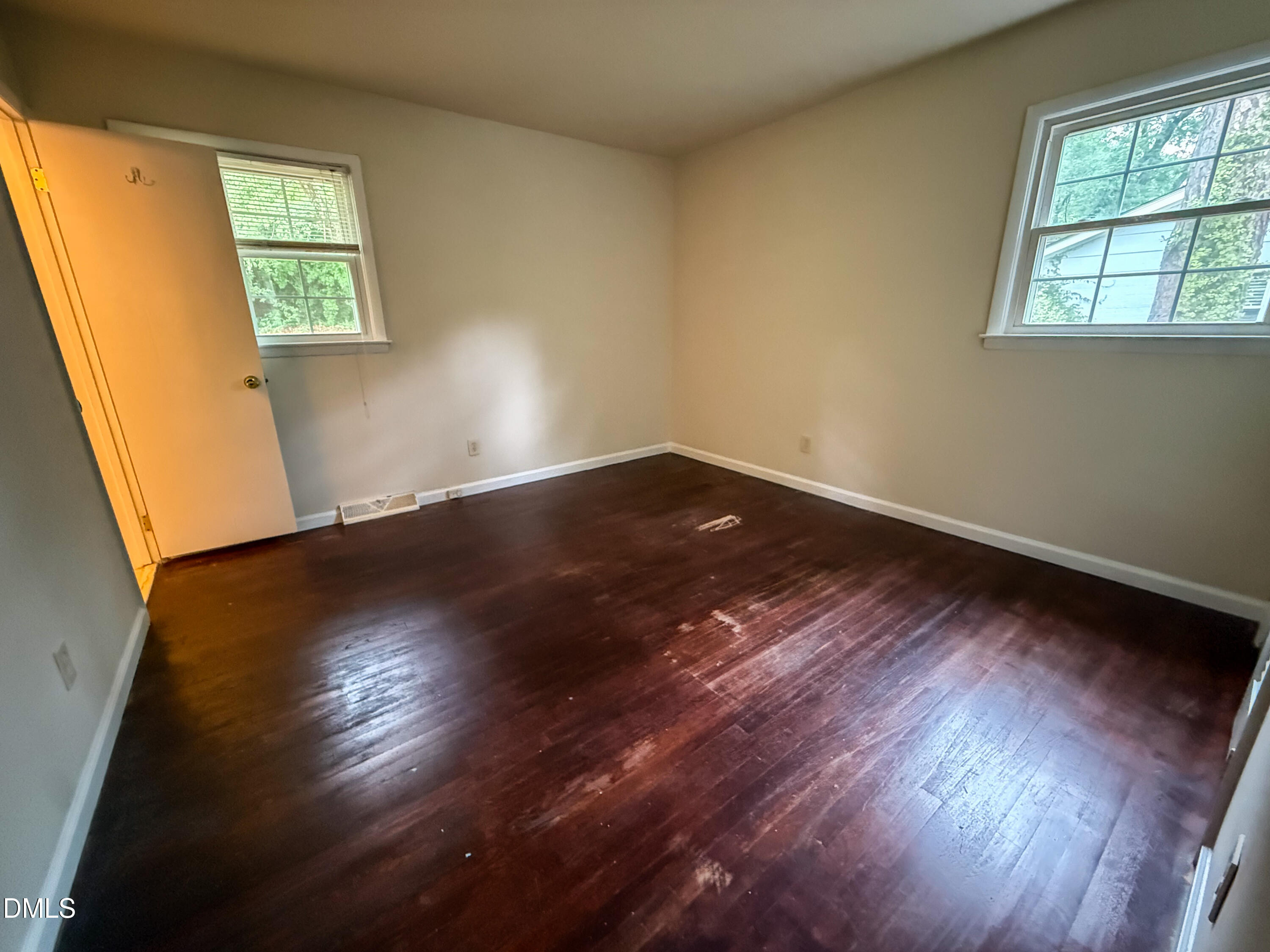 4717 Radcliff Road Raleigh, NC 27609 - Photo 5 of 11 an empty room with wooden floor and windows