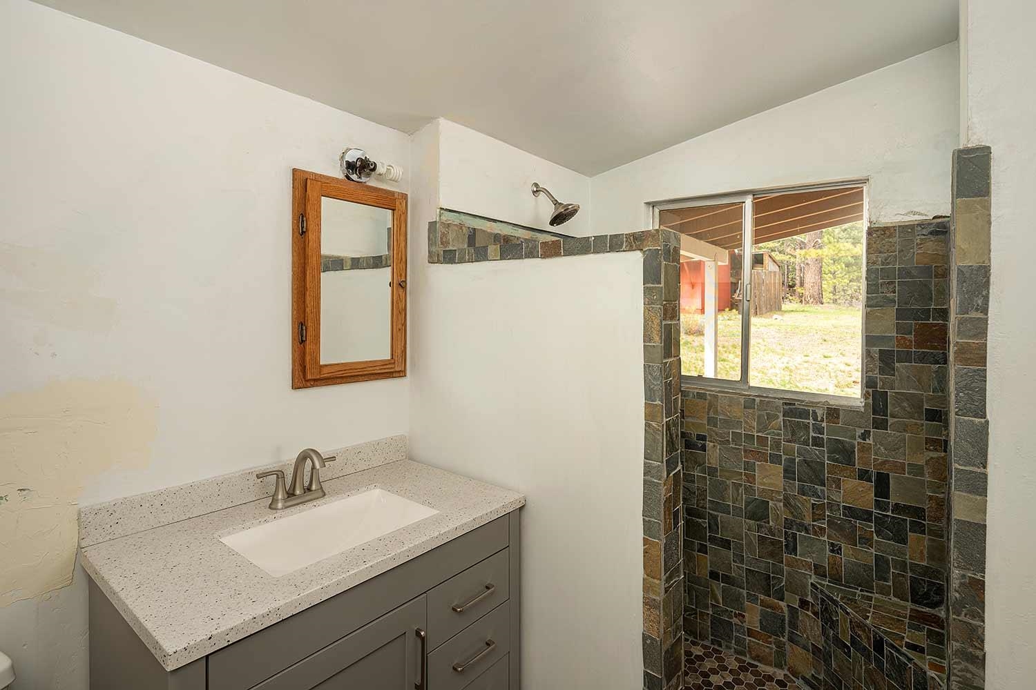 318 Coates Avenue Calpine, CA 96124 - Photo 13 of 21 a bathroom with a granite countertop sink a mirror a shower and a vanity