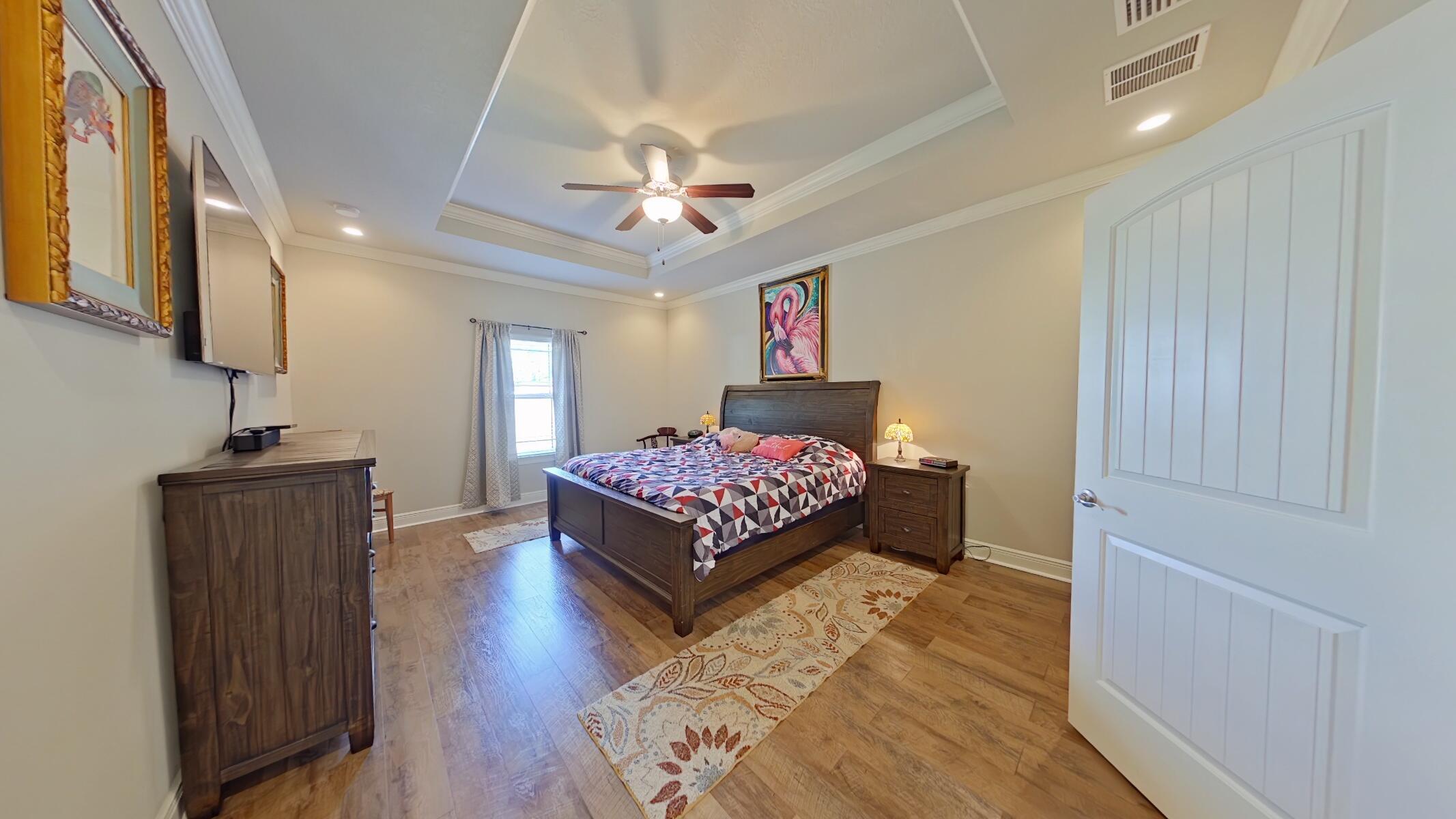 8686 El Paseo Street Navarre, FL 32566 - Photo 13 of 39 a bedroom with a bed and a chandelier