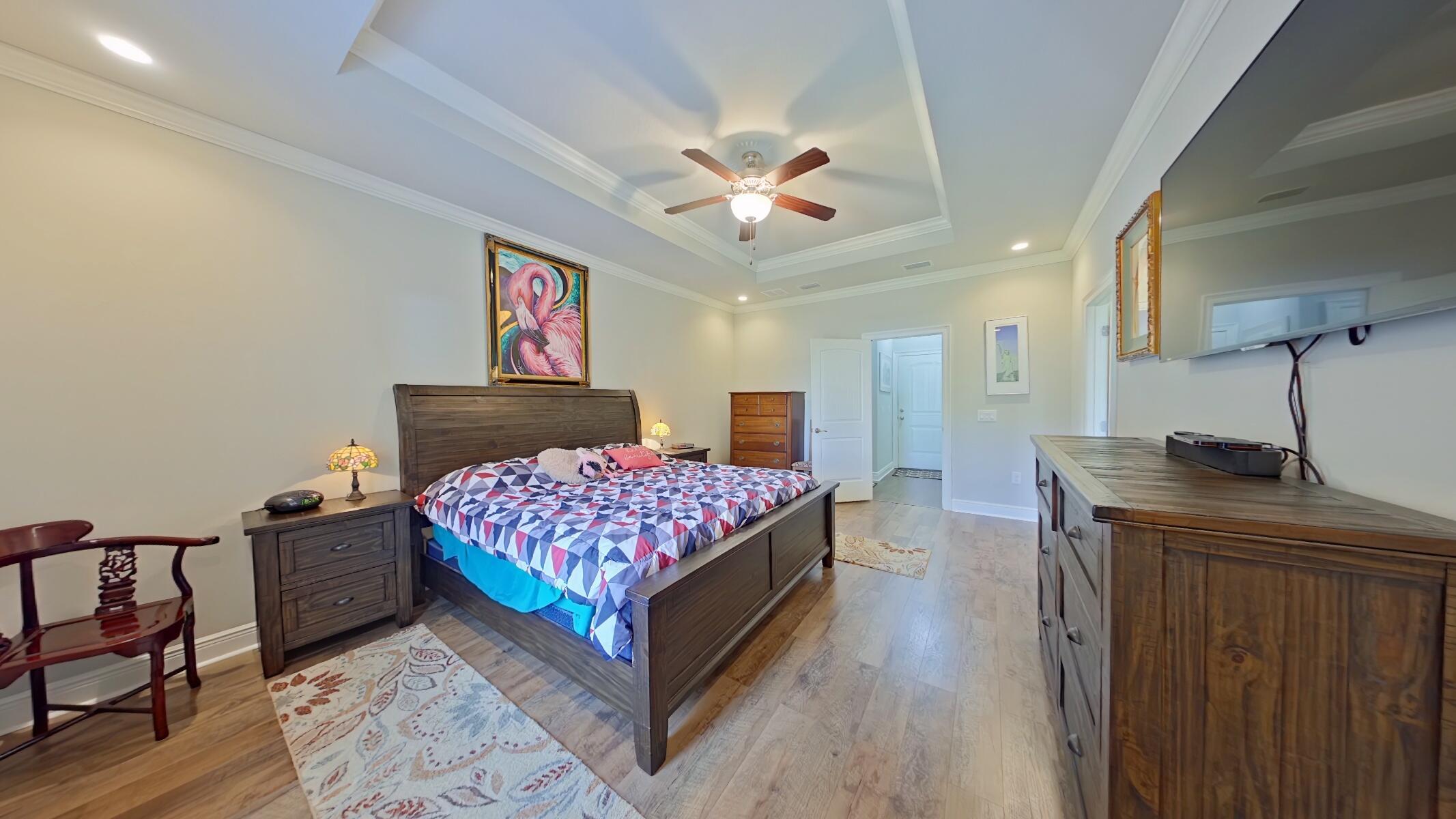 8686 El Paseo Street Navarre, FL 32566 - Photo 14 of 39 a bedroom with a bed and a chandelier