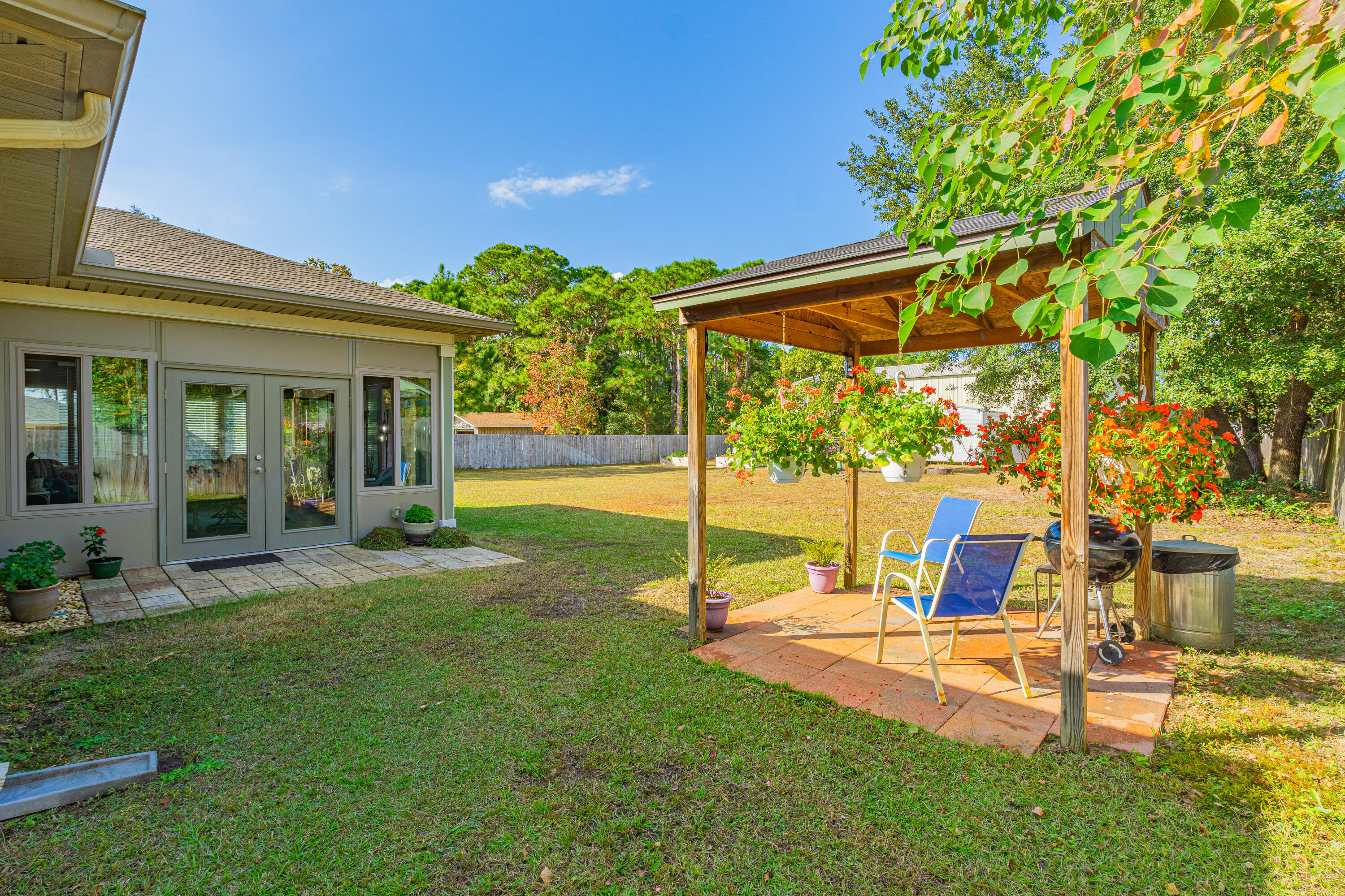 8686 El Paseo Street Navarre, FL 32566 - Photo 28 of 39 a view of a house with backyard porch and sitting area
