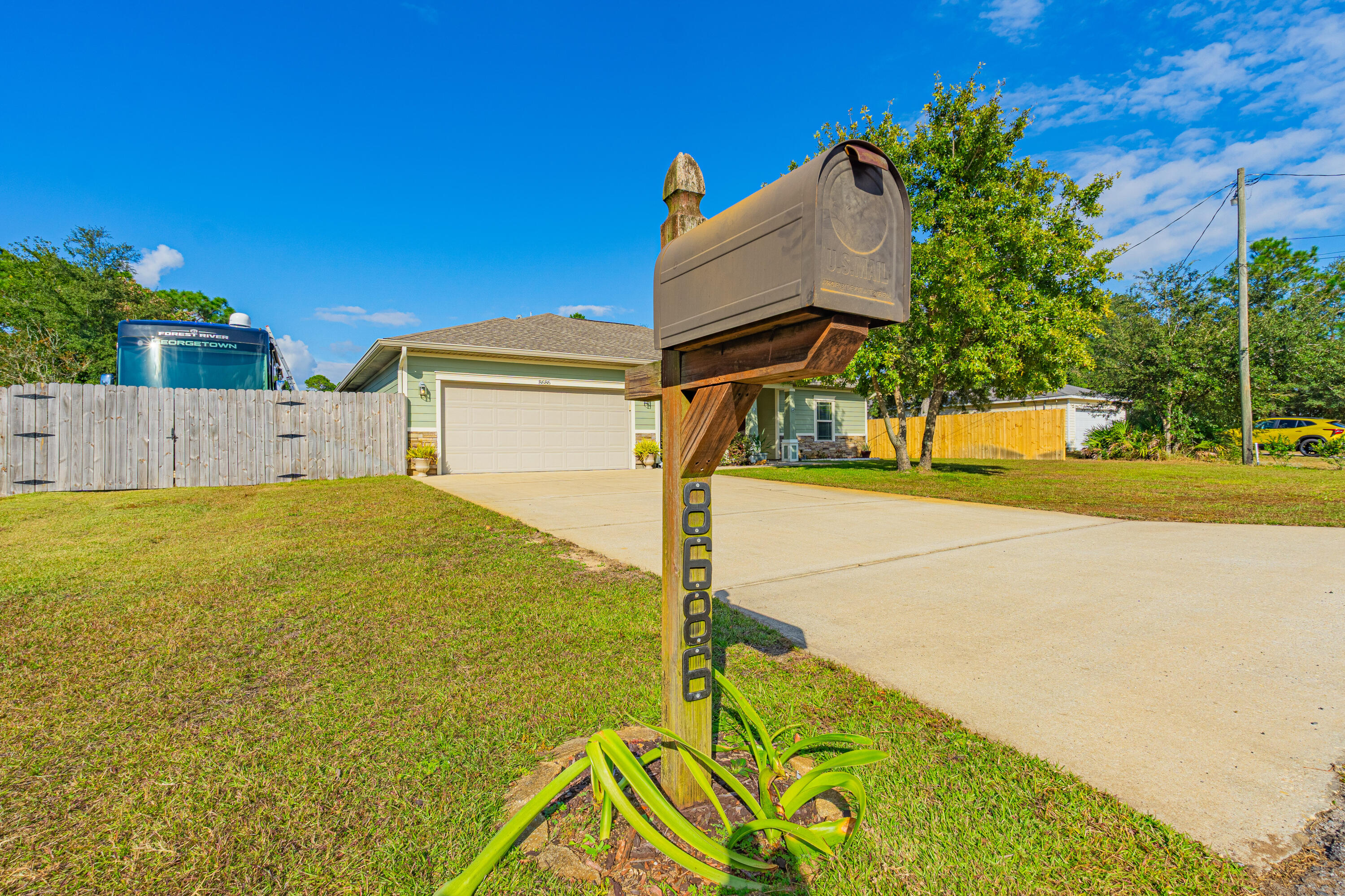 8686 El Paseo Street Navarre, FL 32566 - Photo 3 of 39 a front view of a house with garden