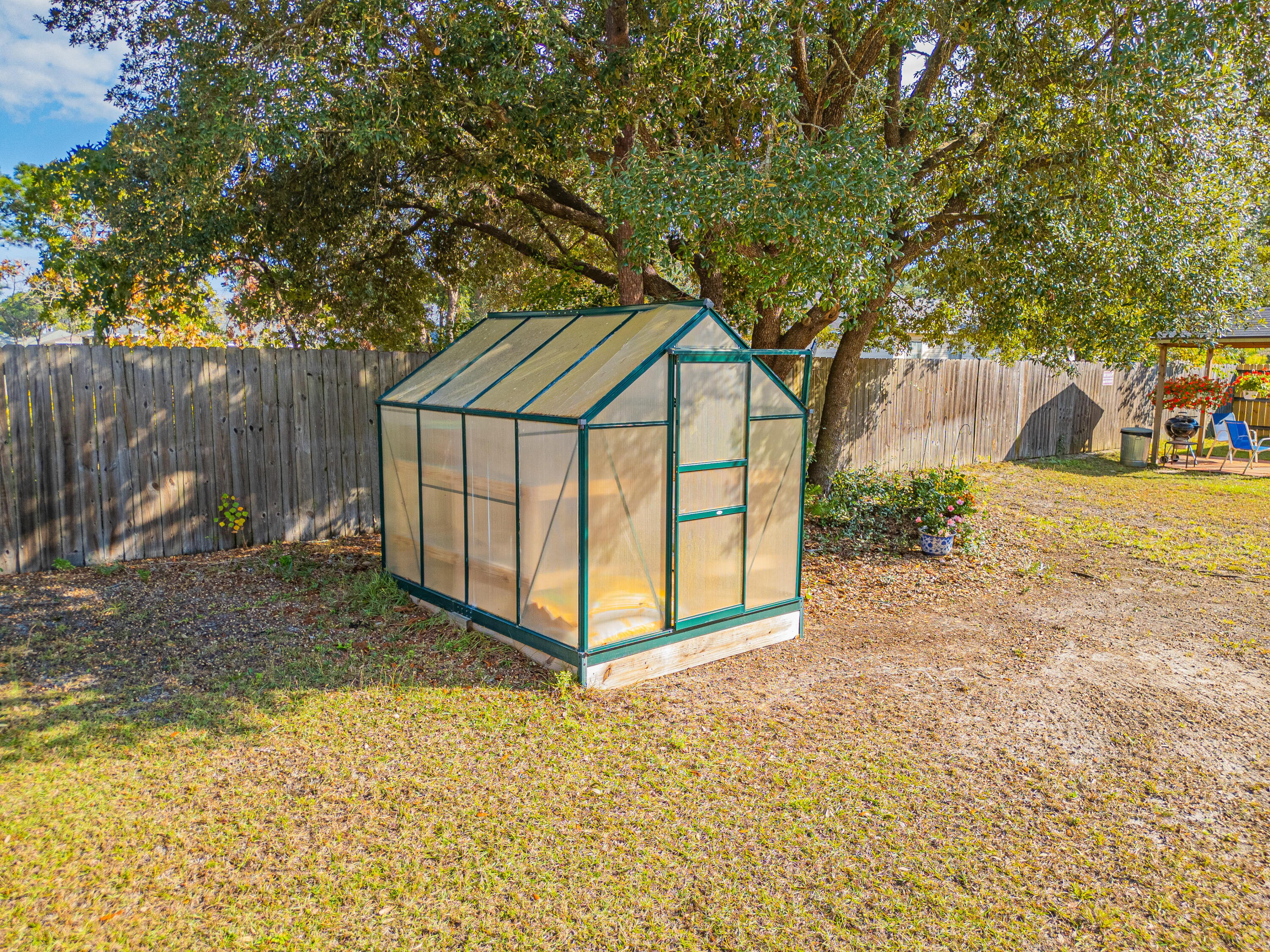 8686 El Paseo Street Navarre, FL 32566 - Photo 35 of 39 a view of backyard with large trees and barn