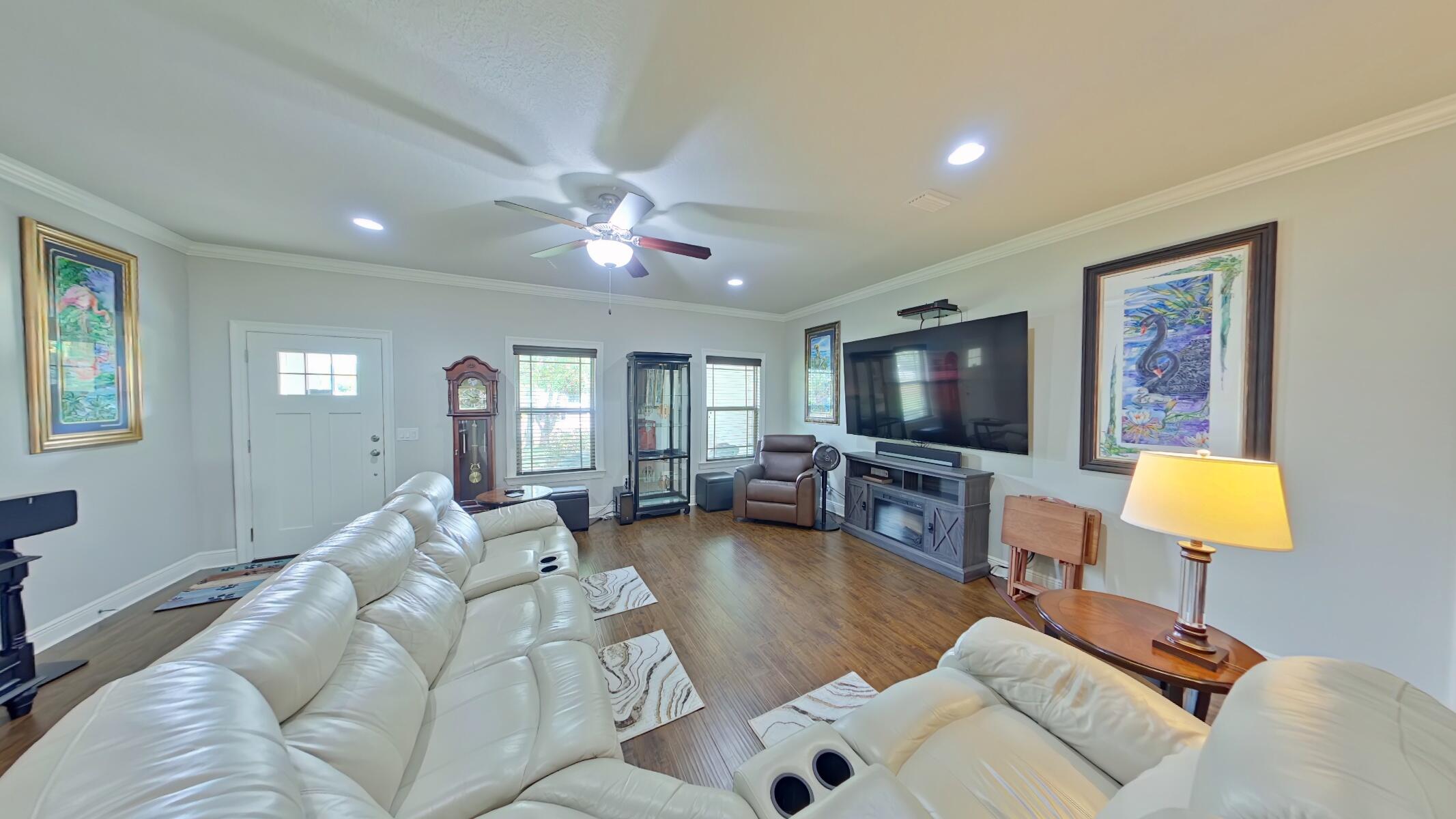 8686 El Paseo Street Navarre, FL 32566 - Photo 5 of 39 a living room with furniture and a flat screen tv