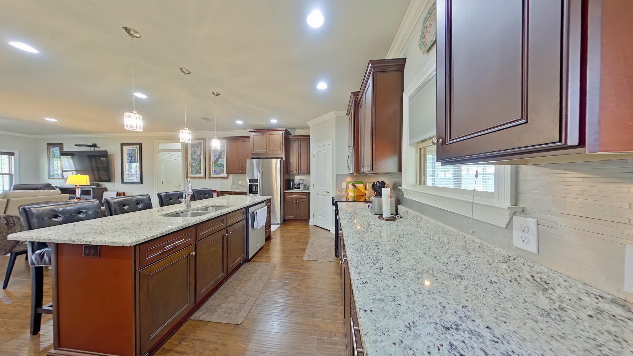 8686 El Paseo Street Navarre, FL 32566 - Photo 10 of 39 a large kitchen with kitchen island a sink stainless steel appliances and cabinets