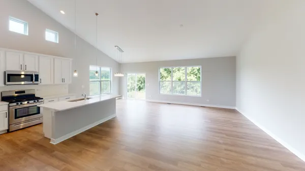 a large kitchen with cabinets wooden floor and stainless steel appliances