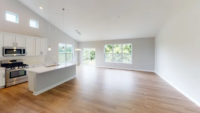 a large kitchen with cabinets wooden floor and stainless steel appliances