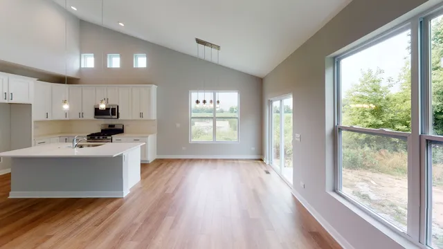 a kitchen with a sink wooden floor and a large window