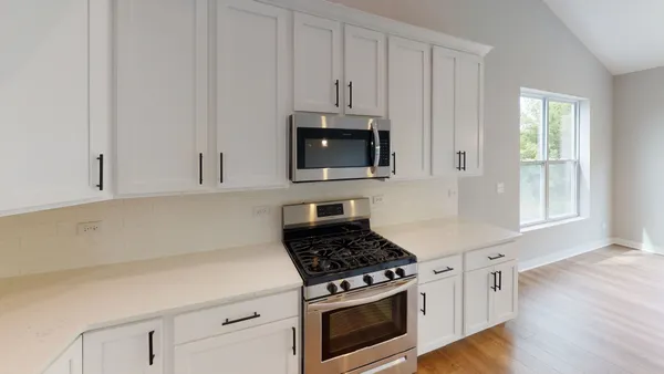 a kitchen with stainless steel appliances a stove a microwave and cabinets