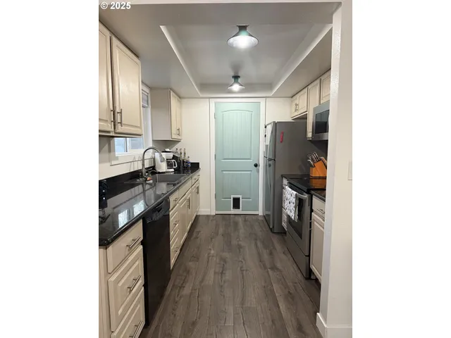 a kitchen with a sink and wooden floor