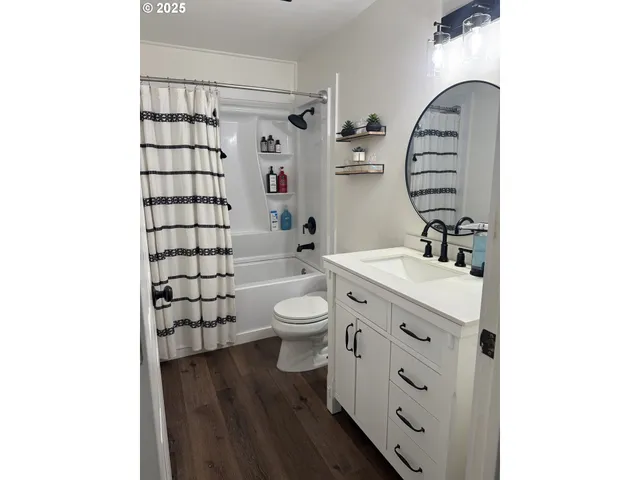 a bathroom with a sink a toilet and shower curtain