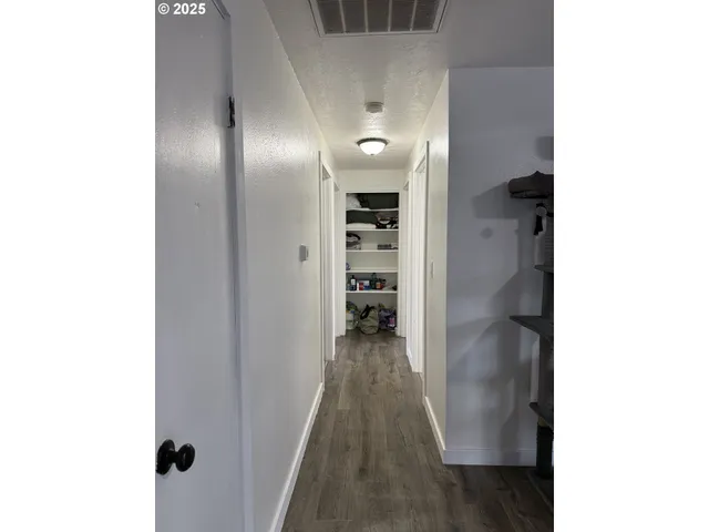 a view of a hallway with wooden floor