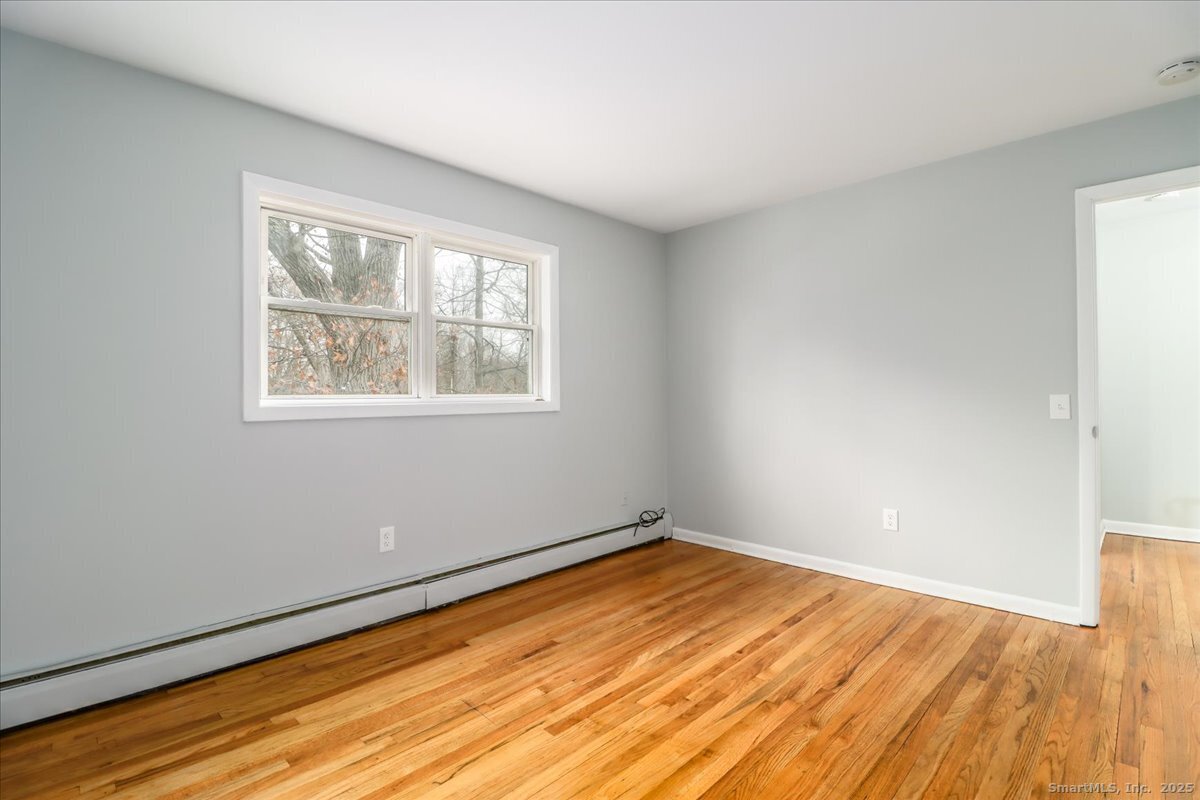 32 Pleasant Street Bethel, CT 06801 - Photo 18 of 29 a view of empty room with wooden floor and fan