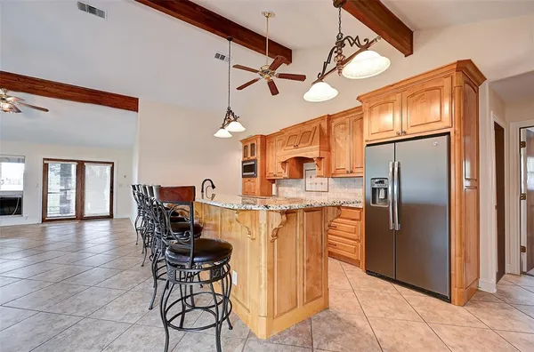 a kitchen with stainless steel appliances kitchen island granite countertop a stove top oven a sink with granite countertops and cabinets