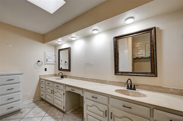 a bathroom with a double vanity sink mirror and bathtub