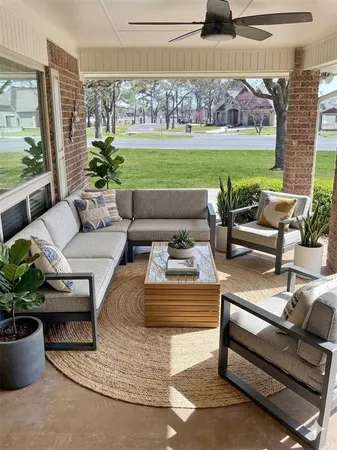 a living room with patio furniture and a garden