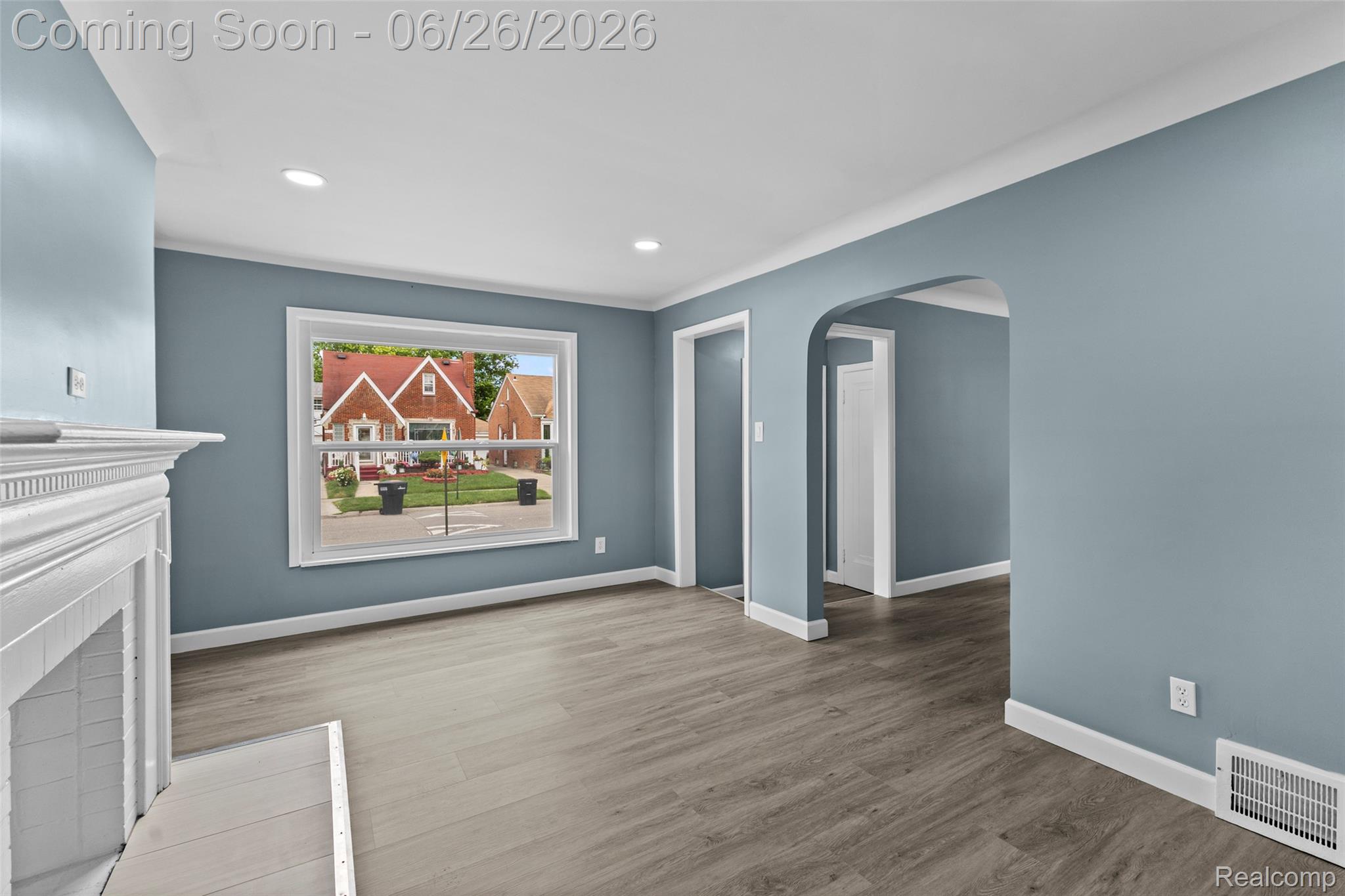 8310 Whitcomb Detroit, MI 48228 - Photo 9 of 26 Living area featuring wood-finish flooring, a white mantel, an arched doorway, and recessed lighting