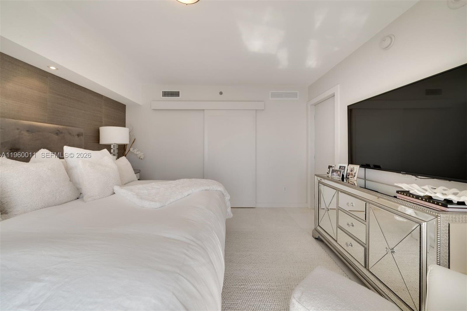 465 Brickell Avenue, Unit 2703 Miami, FL 33131 - Photo 11 of 40 a bedroom with a flat screen tv on the dresser and a sink