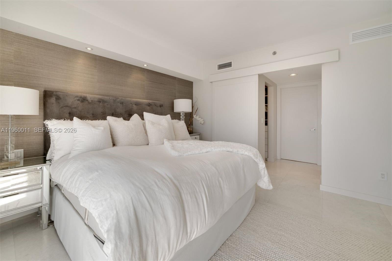 465 Brickell Avenue, Unit 2703 Miami, FL 33131 - Photo 12 of 40 a bedroom with a bed and a night stand