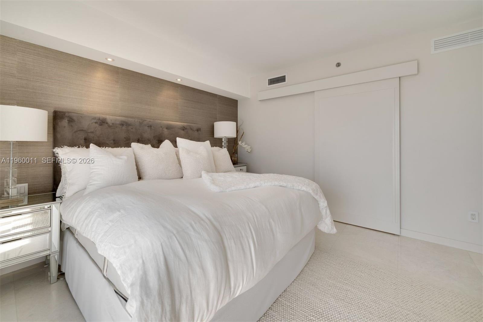 465 Brickell Avenue, Unit 2703 Miami, FL 33131 - Photo 13 of 40 a bedroom with a bed and a night stand