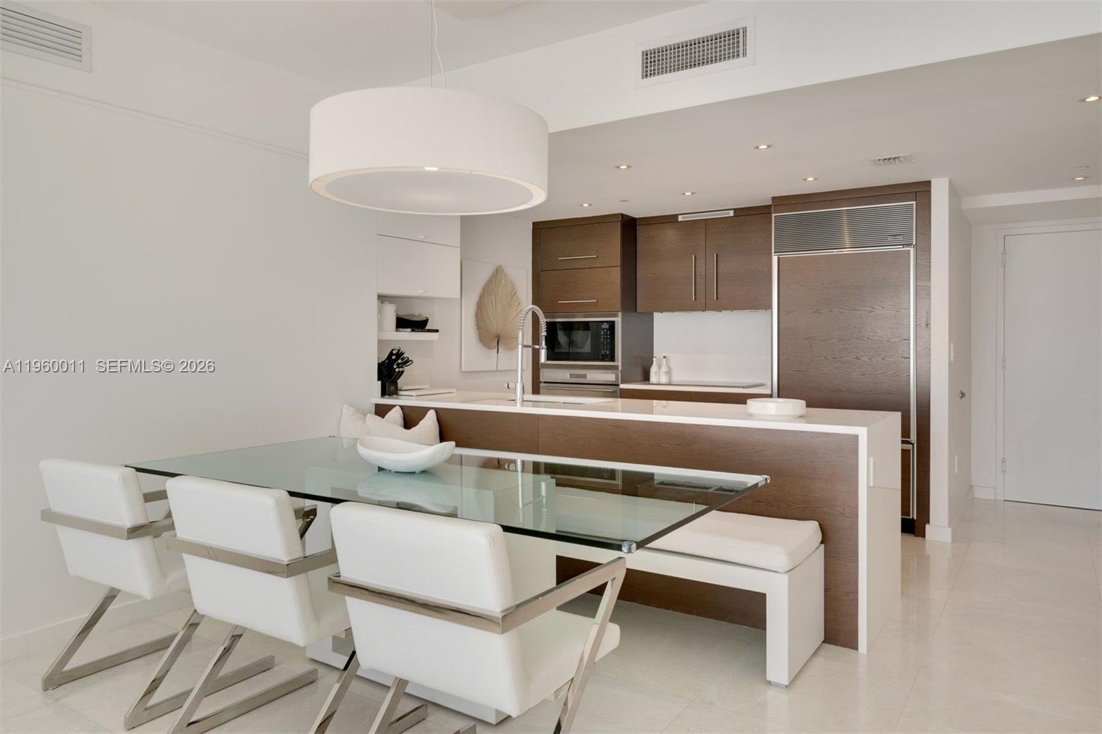 465 Brickell Avenue, Unit 2703 Miami, FL 33131 - Photo 6 of 40 a kitchen with a dining table chairs and a refrigerator
