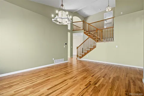 a view of a room with wooden floor and staircase