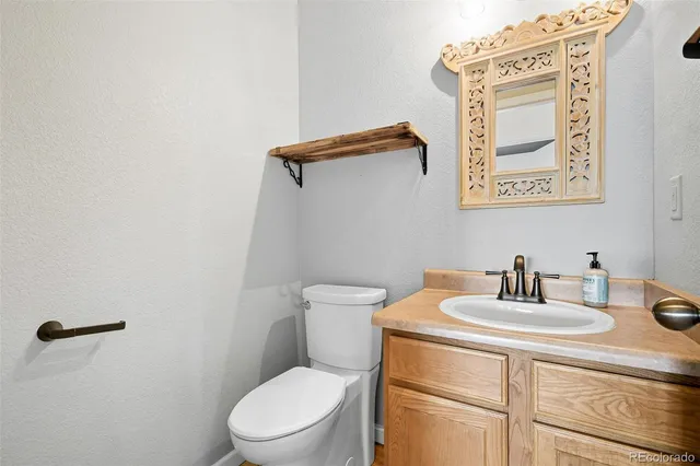 a bathroom with a toilet a sink and mirror