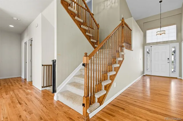 a view of a hallway with wooden floor and staircase
