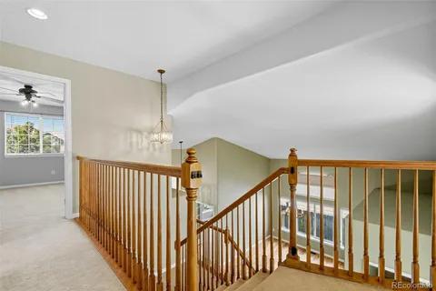 a view of staircase with railing and a chandelier