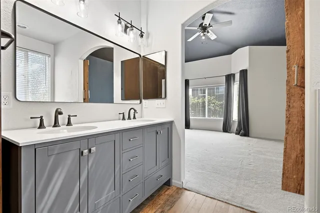 a spacious bathroom with a double vanity sink a large mirror and shower