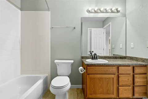 a bathroom with a granite countertop sink toilet and a mirror