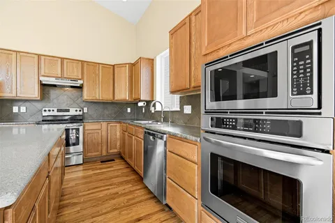 a kitchen with stainless steel appliances a stove a microwave sink and cabinets