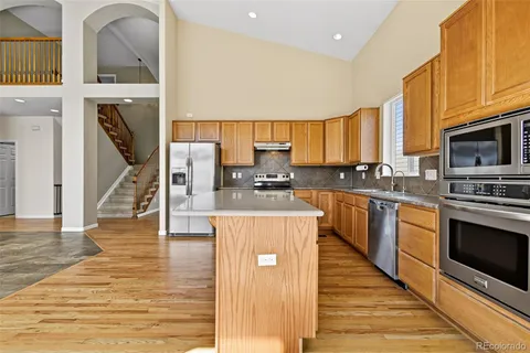 a kitchen with stainless steel appliances granite countertop a stove a sink and a microwave