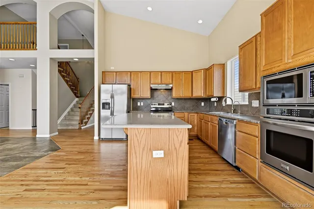 a kitchen with stainless steel appliances granite countertop a stove a sink and a microwave